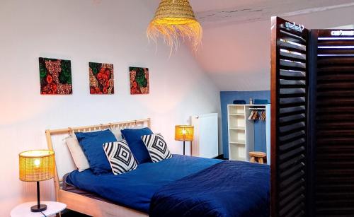 a bedroom with a blue bed and two lamps at Pou-Spa in Spa