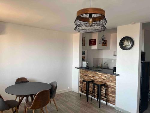 une cuisine et une salle à manger avec une table et des chaises dans l'établissement T1 Bis avec vue sur les iles sanguinaires !, à La Celle-sous-Gouzon