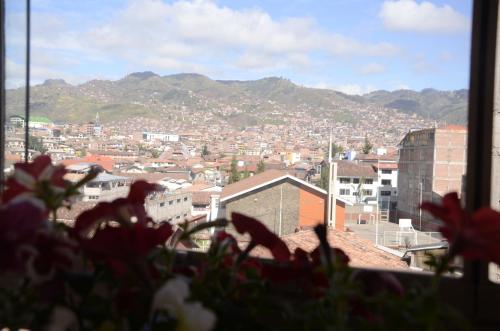 a view of a city from a window with flowers at Aqua Hotel Cusco in Cusco