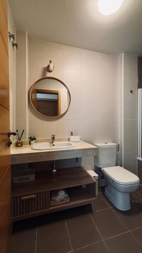a bathroom with a sink and a toilet and a mirror at Luna home in Torrox