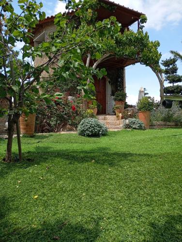 a house with a green yard with a tree at Traditional Windmill-Milos in Kroústas