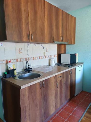 una cucina con lavello e mobili in legno di Heaven Apartment a Ohrid
