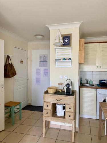 - une cuisine avec une table et une bouilloire dans l'établissement Appartement rez-de-chaussée entre dunes et ocean, à Lacanau-Océan