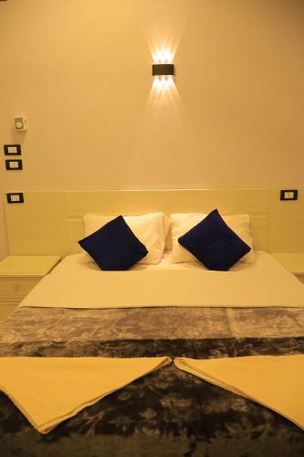 a bed with two blue pillows on top of it at Rayan Nubian Guest House in Aswan