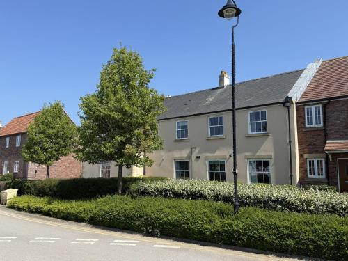 a street light in front of a white house at Dudleys Retreat - Part of the The Bay Filey Holiday Village with pool, gym and direct beach access, pub, restaurant, tennis and meadows walks in Filey