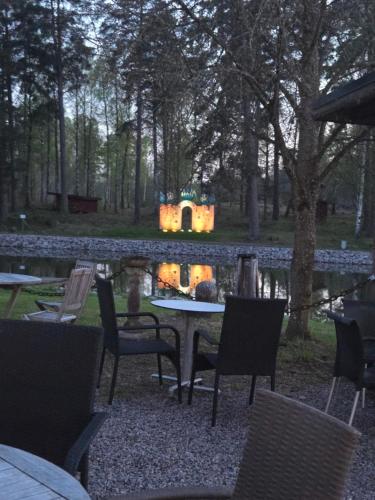 a table and chairs in front of a pond at Norrqvarn Hotel & Resort by Vänerport in Lyrestad