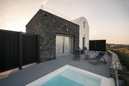 a patio with a swimming pool and a building at Uranides Luxury Suites in Santorini