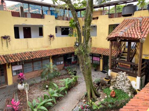 a large yellow building with a garden in front of it at Pousada Boiçucanga in São Sebastião