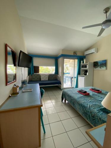 a living room with a bed and a desk in a room at CoCoKreyol - Ti CARAYOU in Les Trois-Îlets