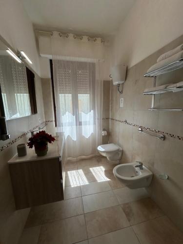 a bathroom with a toilet and a bidet and a sink at B&B I Gerani in Alghero