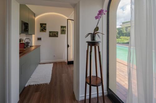 a hallway with a vase of flowers on a stool at Casa dos Arcos - Studios & Pool in Ponta Delgada