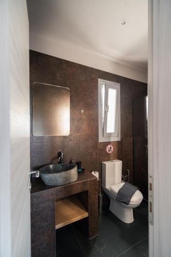 a bathroom with a sink and a toilet at Uranides Luxury Suites in Santorini