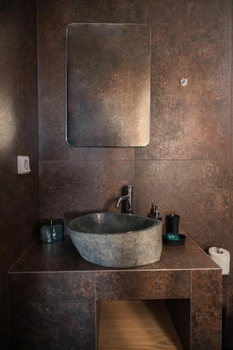 a bathroom with a sink and a mirror at Uranides Luxury Suites in Santorini
