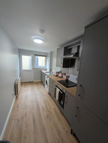 a kitchen with wooden floors and a kitchen with a stove at Fountain Street in Bessbrook