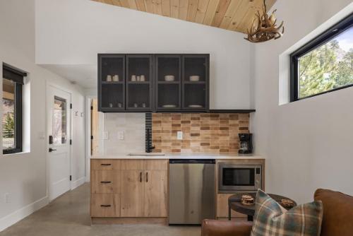 a kitchen with black and white cabinets and a living room at Modern Cabin Stay Hike Bike Base GuanellaPass in Grant