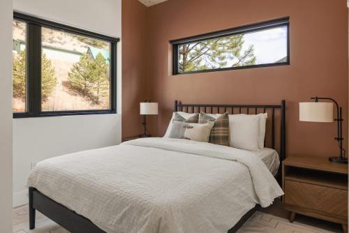 a bedroom with a bed and two windows at Cutthroat Trout Cabin Near Trails Hike and Bike in Grant