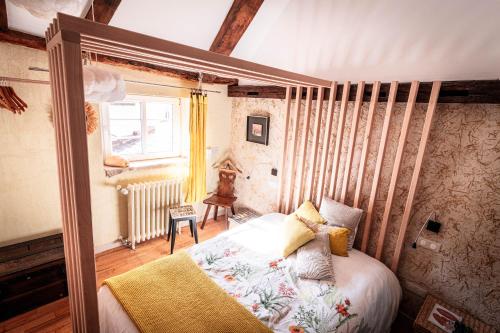 Un dormitorio con una cama en una habitación con ventana. en Moulin de Schwabwiller, en Schwabwiller