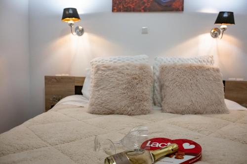a bed with white pillows and a bottle of champagne at Chez Kiki et Ioannis in Naxos Chora