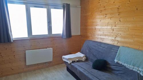 sala de estar con sofá azul y ventanas en Résidence Podium - POD708 STUDIO 4 PERSONNES STATION 1600 MAE-0223, en Puy-Saint-Vincent