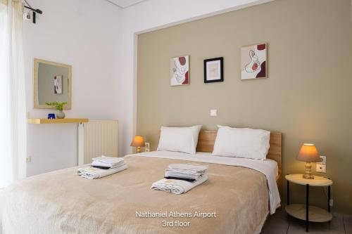 a bedroom with a large bed with towels on it at Nathaniel Athens Airport in Spata