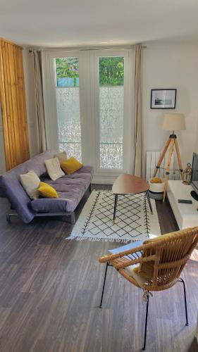 a living room with a couch and a table at Agréable petit gîte avec jardinet et piscine in Salies-de-Béarn