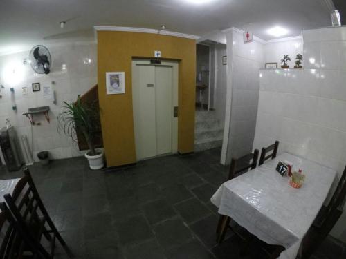 a dining room with a table and a yellow door at Hotel Aparecida do Norte in Aparecida
