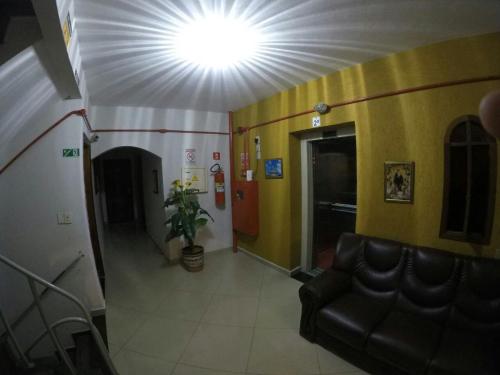 a waiting room with a couch and a light on the ceiling at Hotel Aparecida do Norte in Aparecida