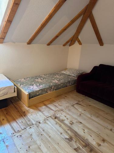 a room with a bed and a couch in a attic at Kuća ispod Rajca in Slavkovica