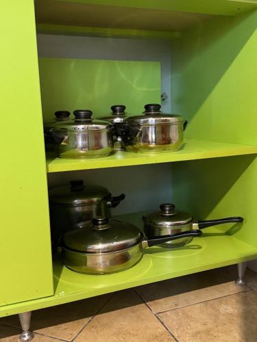 a bunch of pots and pans on a shelf in a kitchen at Kuća ispod Rajca in Slavkovica