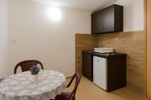 una piccola cucina con tavolo e piccolo frigorifero di Apartments Lejla a Dobra Voda