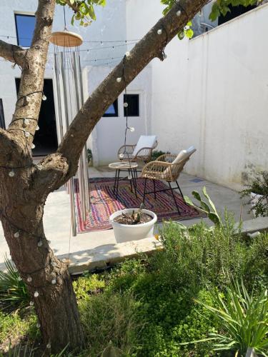 a patio with a table and chairs and a tree at Dimora Rosa in Presicce