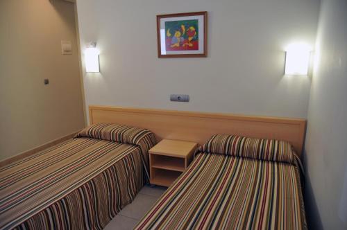 a hotel room with two beds and two lamps at Hotel Blauet by Bossh Hotels in El Prat de Llobregat