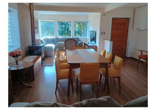 una sala da pranzo con tavolo, sedie e divano di Casa CrisLuz a Pinto