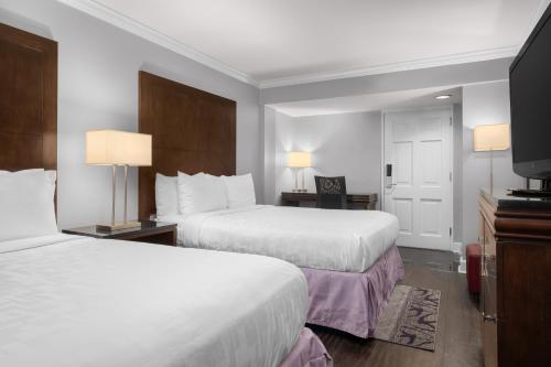 a hotel room with two beds and a flat screen tv at Hotel Le Marais in New Orleans