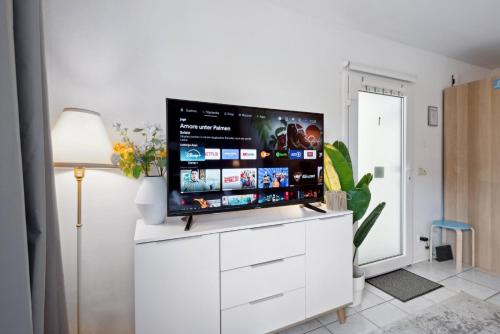 a living room with a flat screen tv on a white cabinet at Gemütliches & Modernes Apartment in Koblenz