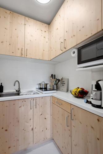 a kitchen with wooden cabinets and a sink at Gemütliches & Modernes Apartment in Koblenz