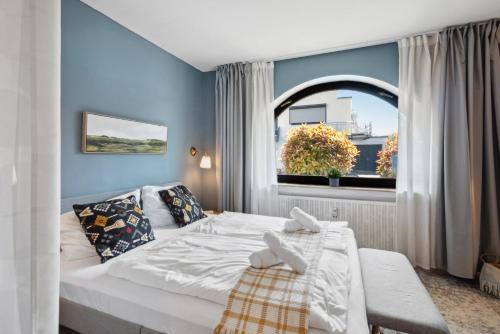 a bedroom with a white bed and a window at Gemütliches & Modernes Apartment in Koblenz