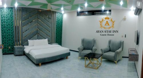 a hotel room with a bed and two chairs at Ayan stay inn in Dargai
