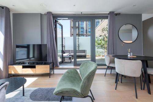a living room with a television and a table and chairs at Stunning Apartment with Private Terrace in London