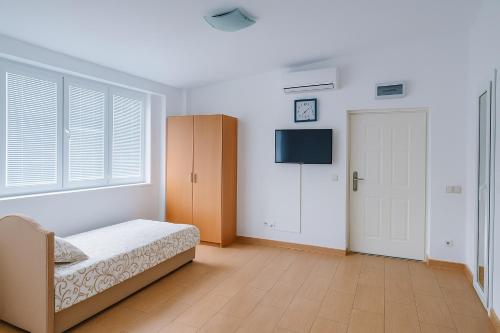 una camera con letto, TV e porta di Apartments Lejla a Dobra Voda