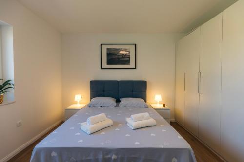 a bedroom with a bed with two pillows on it at Martha's Oliveyard in Biograd na Moru