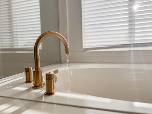 a kitchen sink with a faucet and a bath tub at Family Retreat Near SLC Airport 6 BR 3 Bath in West Valley City