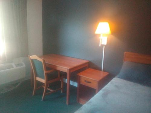 a bedroom with a table and a lamp next to a bed at 2 Double Beds Hotel Studio 137 in Livingston