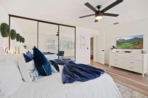 パーム・スプリングスにある4Bd l Pool & Tennis Access l 5 mi downtown PSのベッドルーム1室(青い枕と天井ファン付きのベッド1台付)