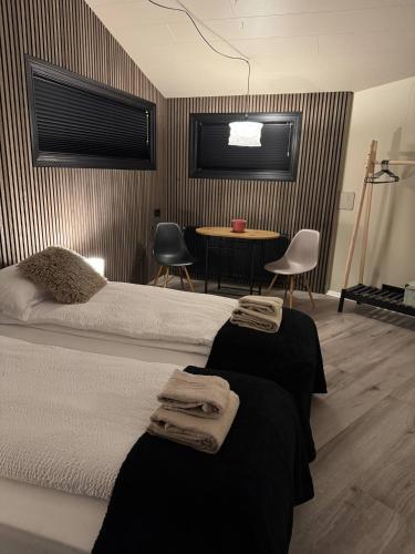 a bedroom with two beds and a table with chairs at The Rock Village Nook in Reykjavík