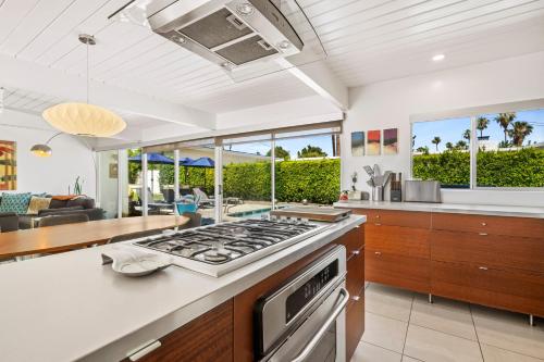 a kitchen and living room with a stove top oven at Alexander Escape - Historic Alexander Home in Palm Springs