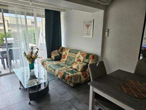 un salon avec un canapé et une table en verre dans l'établissement Résidence Héliovillage - VILLA T3 - 4 pers. CAP d'AGDE MAE-9611, au Cap d'Agde