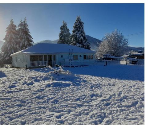 un cortile coperto da neve con una casa sullo sfondo di Casa CrisLuz a Pinto