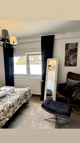 ein Schlafzimmer mit einem Bett, einem Spiegel und einem Stuhl in der Unterkunft Deluxe Apartement mit Terrasse in Duisburg