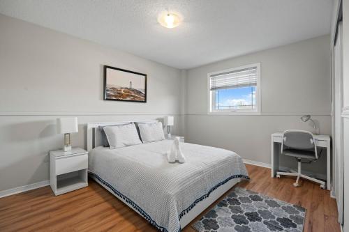 a bedroom with a bed and a desk and a chair at Entire 5 bedrooms House in Barrie